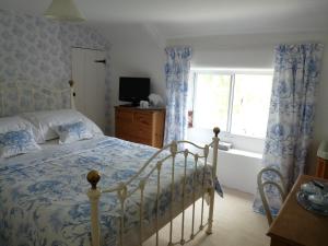 a bedroom with a bed and a window and a tub at The Willows in Shillingstone