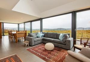 sala de estar con sofá y mesa en Luxury coastal retreat with stunning views, en Aultbea