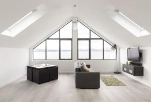 una sala de estar con sofá y TV en un loft en 1 Bed Studio - Sleeps 4 - Parking - Wifi, en Saint Davids
