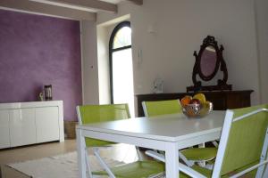 een eetkamer met een witte tafel en groene stoelen bij Charming 1-Bed Apartment in Castell'Arquato in CastellʼArquato