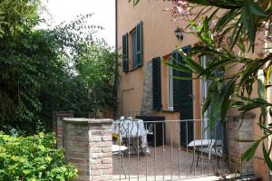 een hek met een tafel en stoelen naast een gebouw bij Charming 1-Bed Apartment in Castell'Arquato in CastellʼArquato