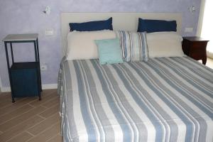 1 cama grande con manta de rayas azul y blanco en Charming 1-Bed Apartment in Castell'Arquato, en CastellʼArquato