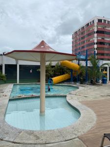 uma piscina com um guarda-sol e um escorrega aquático em Aquarius Residence Caldas Novas 701D em Caldas Novas