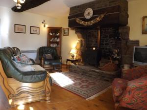 uma sala de estar com uma grande lareira de pedra em Beautiful 3-Bed Cottage in Passais-Villages em Saint-Siméon