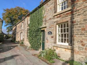 an ivycovered brick building with a door and a window at Beautiful 3-Bed House in Longnor near Buxton in Longnor
