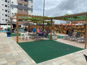 un patio con sillas y una alfombra verde en Aquarius Residence Caldas Novas 701D, en Caldas Novas