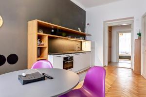 a kitchen with a table and purple chairs at Modern apartment 10 minutes from Old Town! in Prague