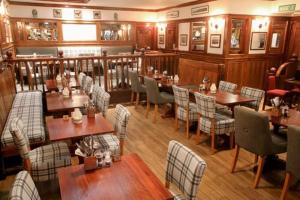 um restaurante com mesas e cadeiras num quarto em The Royal Hotel em Stromness