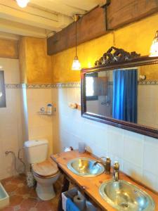 a bathroom with two sinks and a toilet and a mirror at Casasdetrevijano Mirador de Mateo in Soto en Cameros +36 photos