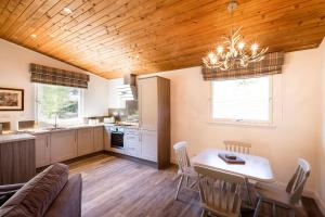 a kitchen and dining room with a table and chairs at Deerstalker chalet in Crianlarich