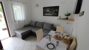 a living room with a couch and a table at Apartments Kovačić in Malinska