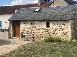 un vecchio edificio in pietra con un tavolo di fronte di The Lake Room Cottage with Private Fishing Lake a Bommiers