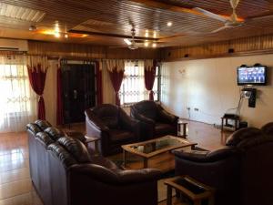 a living room with leather furniture and a television at A Spacious 3 Bedroom House in Kumasi