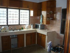a kitchen with a sink and a microwave at A Spacious 3 Bedroom House in Kumasi