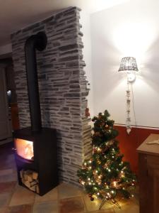 einen Kamin mit einem Weihnachtsbaum daneben in der Unterkunft Ferienhaus Aloisia in Sankt Michael im Lungau