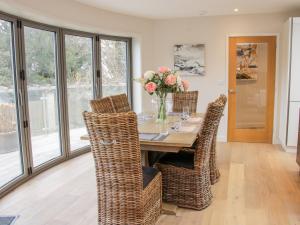 a dining room with a table with wicker chairs at Round House in Church Stretton