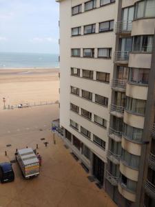 a view of the beach from the balcony of a building at Knus appartement met zijdelings zeezicht in Ostend