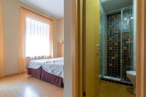 a bathroom with a bed and a glass shower at Herzen House in Saint Petersburg
