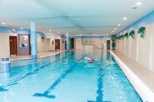 uma pessoa a nadar numa piscina interior em Hibernian Hotel & Leisure Centre em Mallow