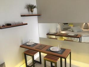 two tables and chairs in a room with a bed at Absolut Confort Suites in Atalaia Velha