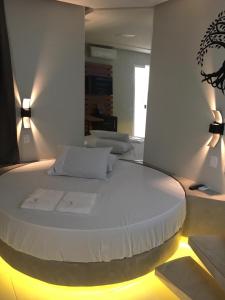a large white bed in a room with lights at Absolut Confort Suites in Atalaia Velha