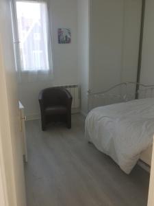 - une chambre avec un lit et une chaise noire dans l'établissement Respire le Bien-être, à Rosny-sous-Bois