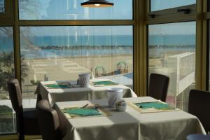 two tables with white table cloths and a view of the ocean at AmbientHotels Panoramic in Rimini