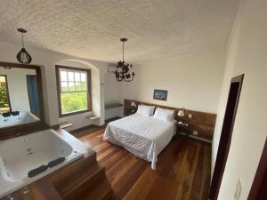 a bedroom with a bed and a bath tub at Hotel Solar Das Lajes in Ouro Preto