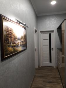 a painting hanging on a wall in a hallway at Апартаменти ЖК"Театральний" in Rivne