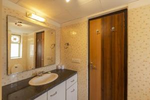 un baño con lavabo y espejo en Aloha Apartments by blissful Ganges, en Rishīkesh 209 fotos más