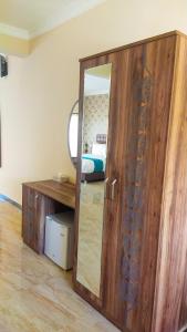 a room with a mirror and a wooden cabinet at Golden Palm Boutique Zanzibar in Zanzibar City