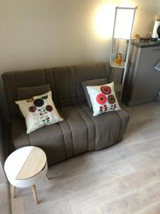 Sofá marrón en la sala de estar con almohadas en La Brigantine, en La Chaume