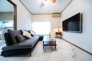 a living room with a couch and a tv at Awaji egaosakuie in Sumoto in Sumoto