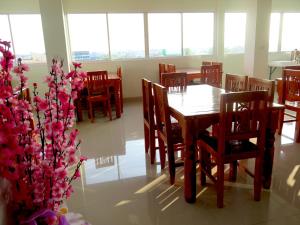 a dining room with a table and chairs and a plant at Euro Boutique Hotel in Chumphon