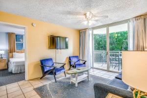 a living room with a couch and chairs and a tv at Sunrise Suites - Sea Breeze Suite 101 in Key West