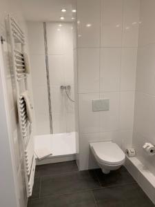 a white bathroom with a shower and a toilet at Steimke's Landhotel in Graue