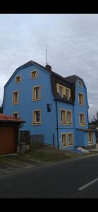 un gran edificio azul con techo negro en Apartmány U Kocoura pod Klínovcem, en Kovářská