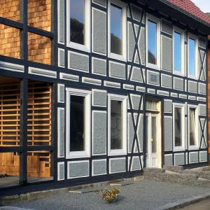 un edificio en blanco y negro con ventanas blancas en WohnWerk Ferienwohnungen Lautenthal, en Langelsheim