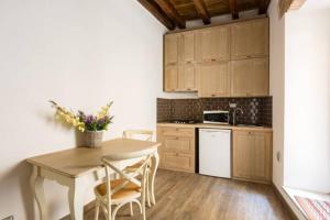 una cucina con tavolo e sedie e una cucina con lavandino di Pellegrino 75 Actual a Roma