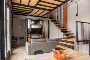 a living room with a couch and a staircase at Lilian Lofts Hotel & Spa in Johannesburg