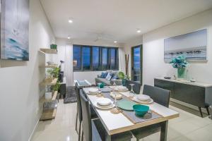 a dining room and living room with a table and chairs at NEW - ZEN AT THE WATERFRONT - Luxury Waterfront Holiday Home for Families & Friends in Darwin