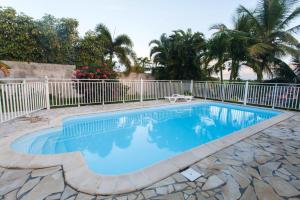 una piscina en un patio con una valla blanca en Appartement d'une chambre avec piscine partagee jardin et wifi a Sainte Anne a 3 km de la plage, en Sainte-Anne