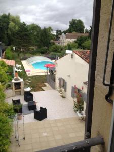 vista su un patio e sulla piscina da un edificio di Studio avec piscine privee jardin clos et wifi a Saint Jean d'Angely a Saint-Jean-dʼAngély