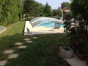 een achtertuin met een zwembad in een tuin bij Studio avec piscine privee jardin clos et wifi a Saint Jean d'Angely in Saint-Jean-dʼAngély