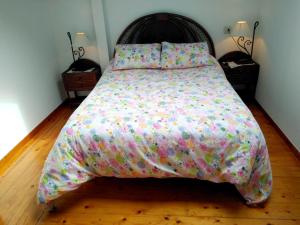 a large bed with a colorful comforter in a bedroom at 2 bedrooms apartement at Llanes 200 m away from the beach with wifi in Llanes