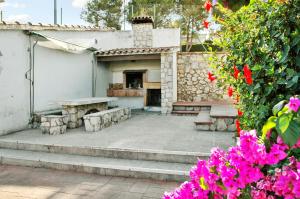 a patio with two benches and a table and flowers at Spacious Apartment in Canyelles with Private Pool in Canyelles