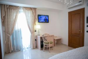 um quarto com uma secretária, uma cadeira e uma janela em Hotel Miramare em Marina di Schiavonea
