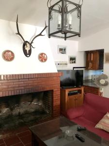 uma sala de estar com lareira e um sofá vermelho em 5 bedrooms villa with private pool enclosed garden and wifi at Aroche Huelva em Aroche