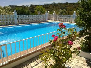 uma vista para uma piscina a partir de uma varanda em 5 bedrooms villa with private pool enclosed garden and wifi at Aroche Huelva em Aroche