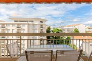 uma varanda com uma mesa e cadeiras e um edifício em Appartement d'une chambre a Cannes a 250 m de la plage avec vue sur la ville balcon amenage et wifi em Cannes